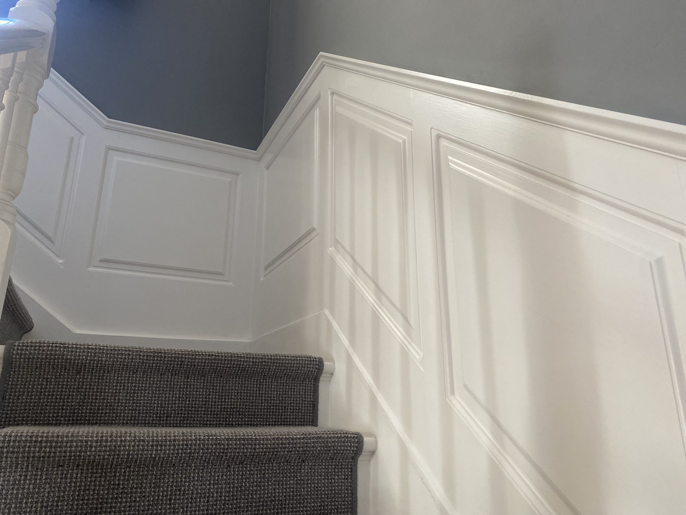 Painted panelling beside a carpeted staircase, fitted by VIP Walls