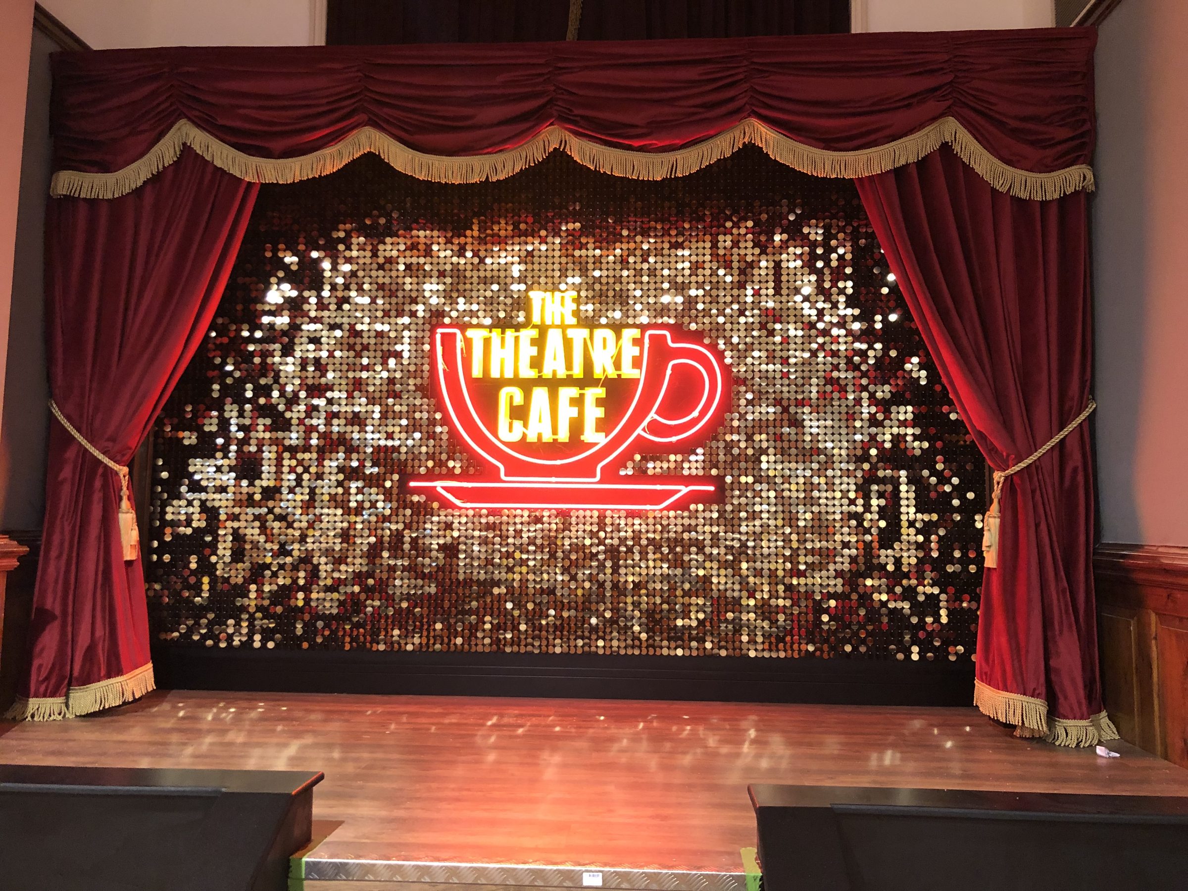 Gold sequin wall forming a stage backdrop, installed by VIP Walls