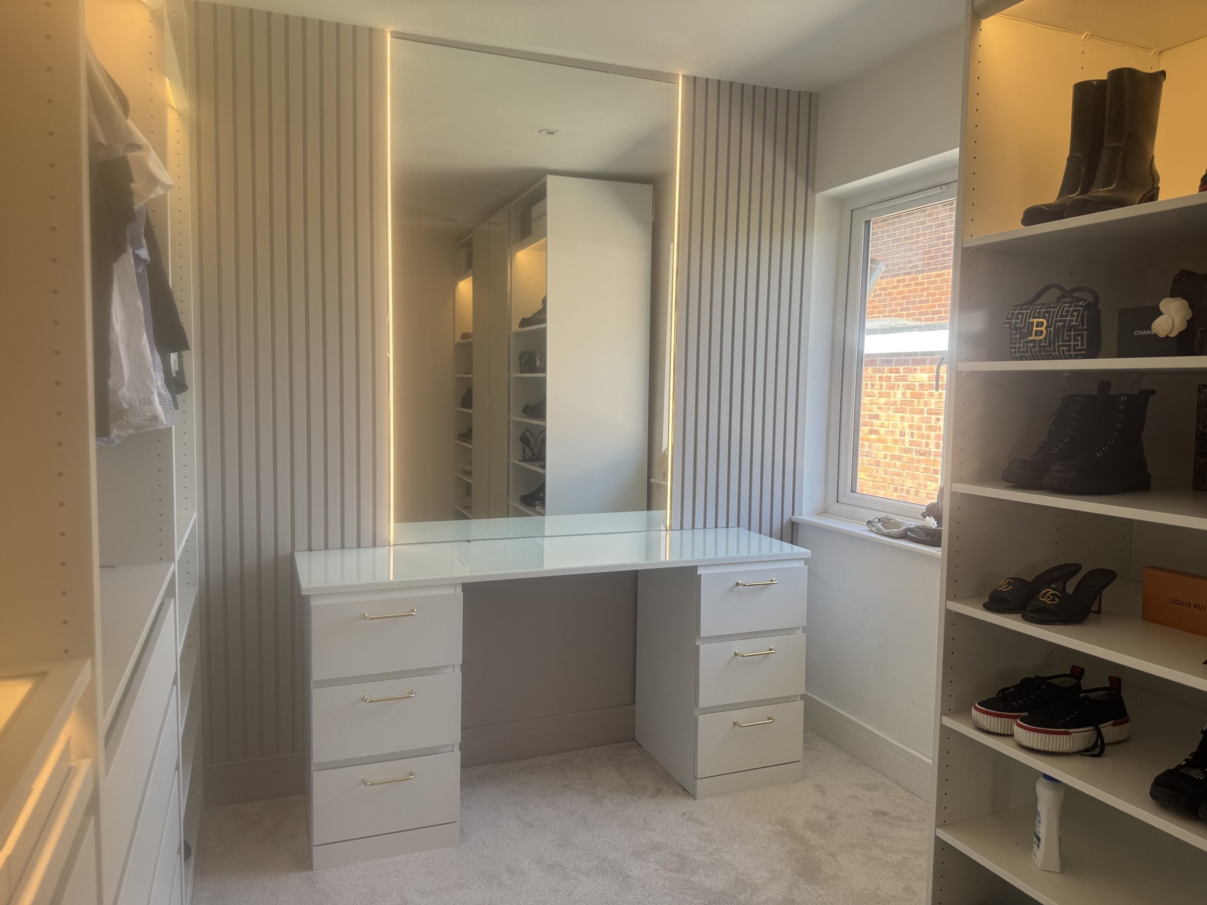 Fitted dressing room with open shoe shelving and a built-in dressing table