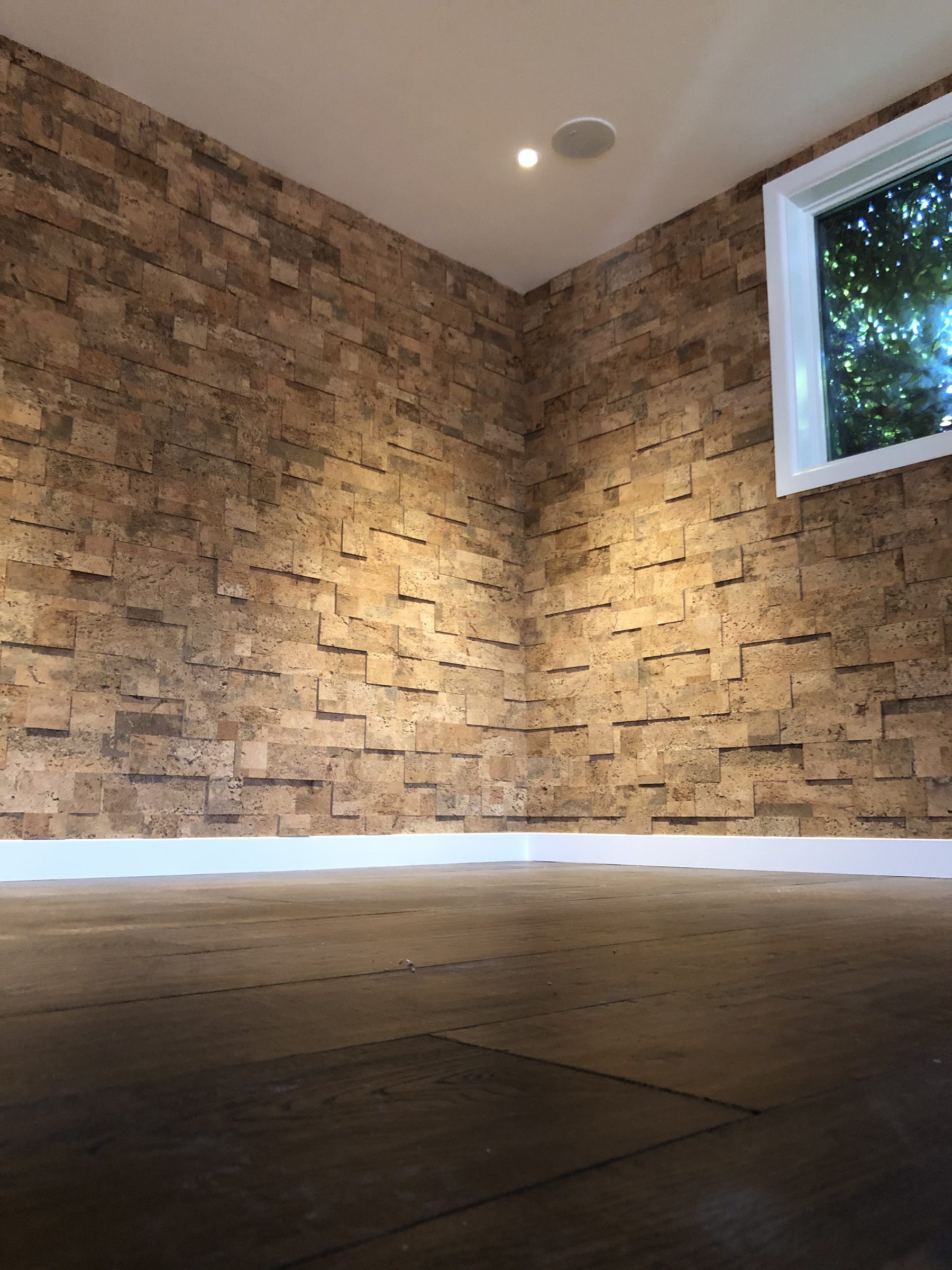 Split face stone feature wall lit from below in a lounge