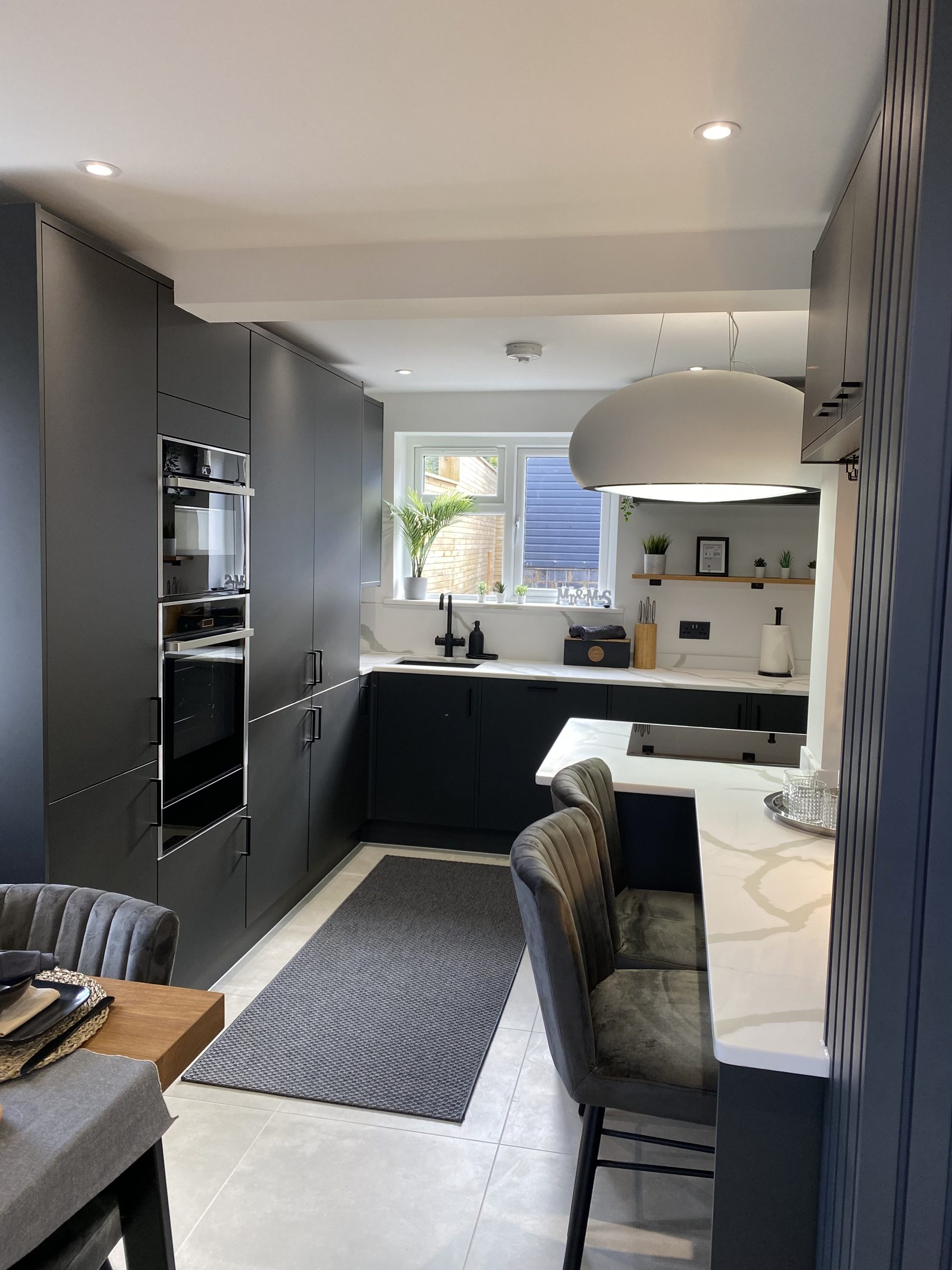 Kitchen with grey cabinetry and integrated appliances fitted by VIP Walls